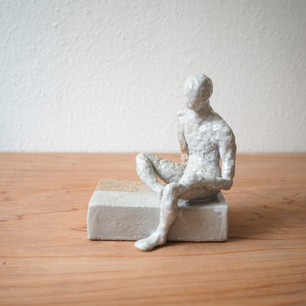 Sitting figure on a slab