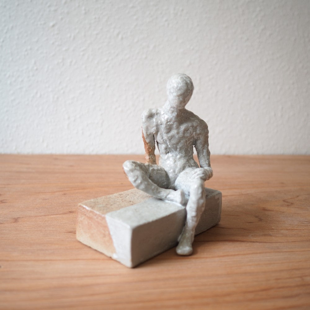 Sitting figure on a slab