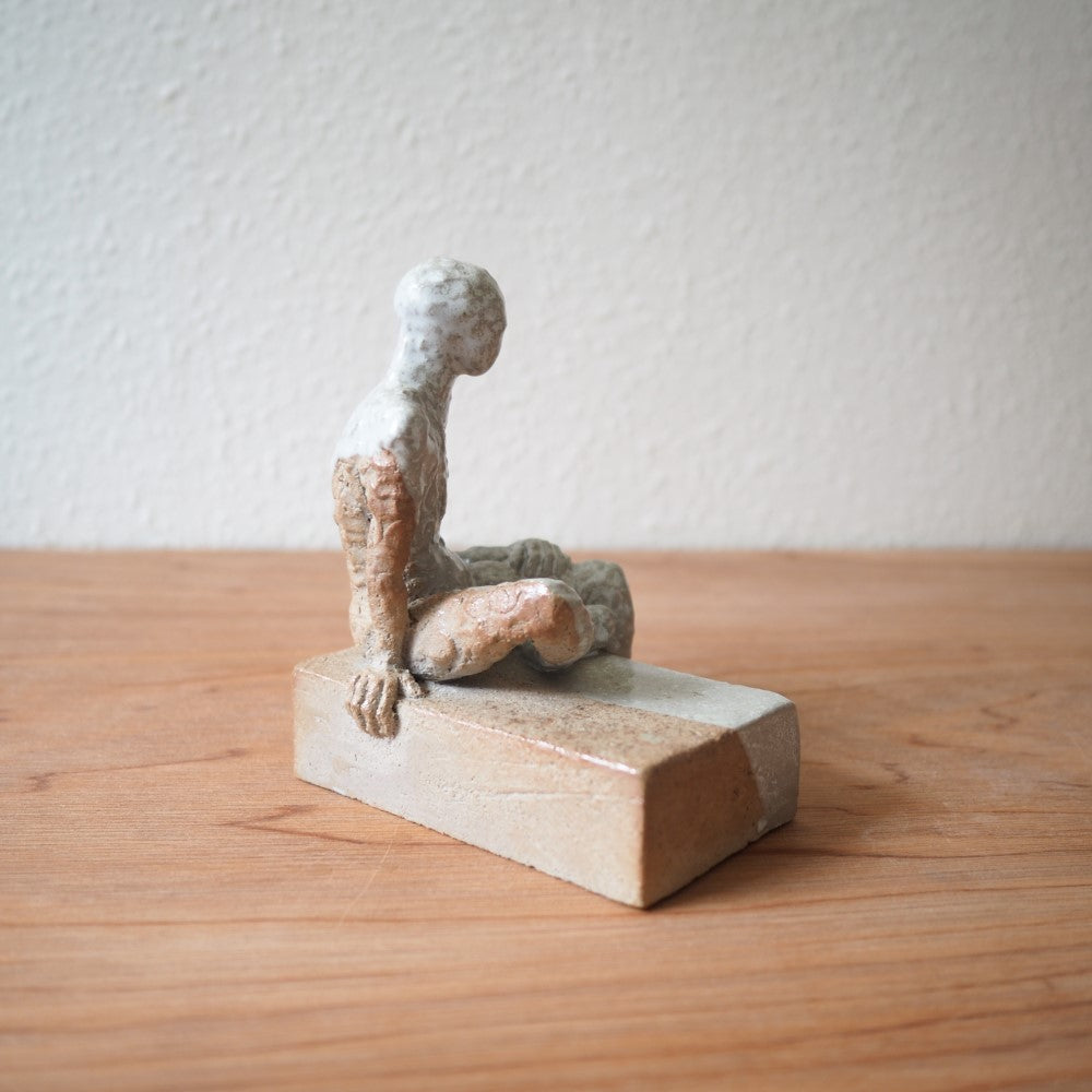 Sitting figure on a slab