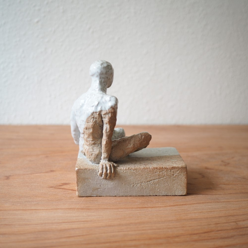 Sitting figure on a slab