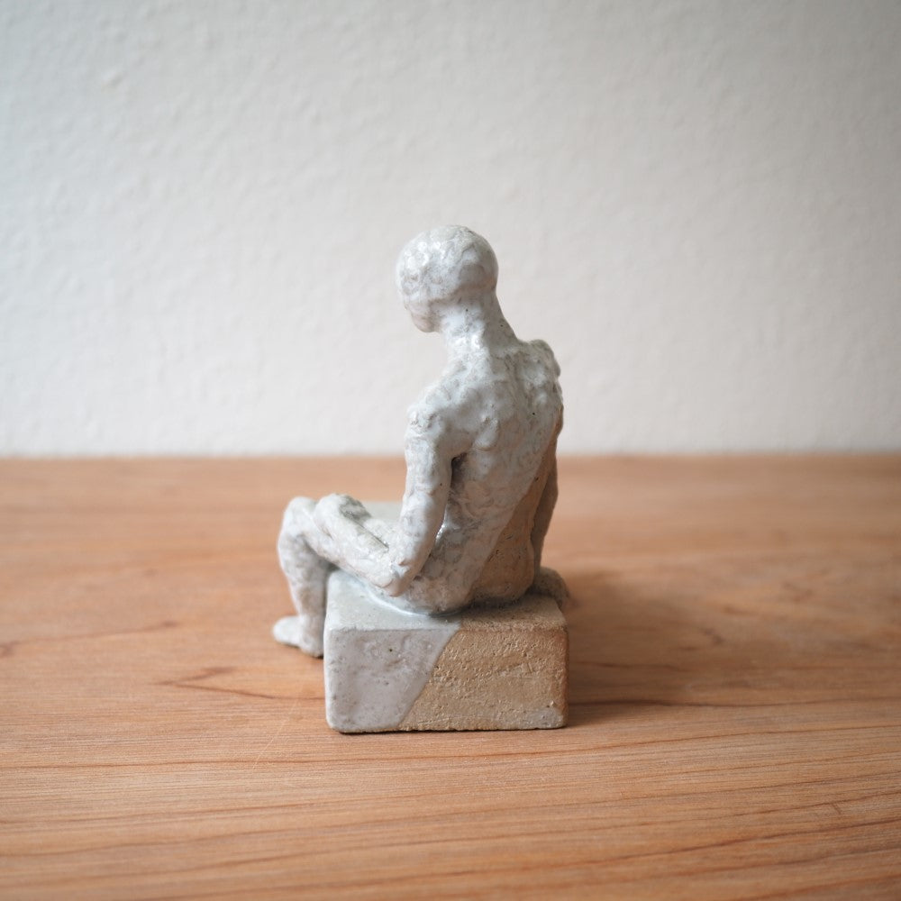 Sitting figure on a slab
