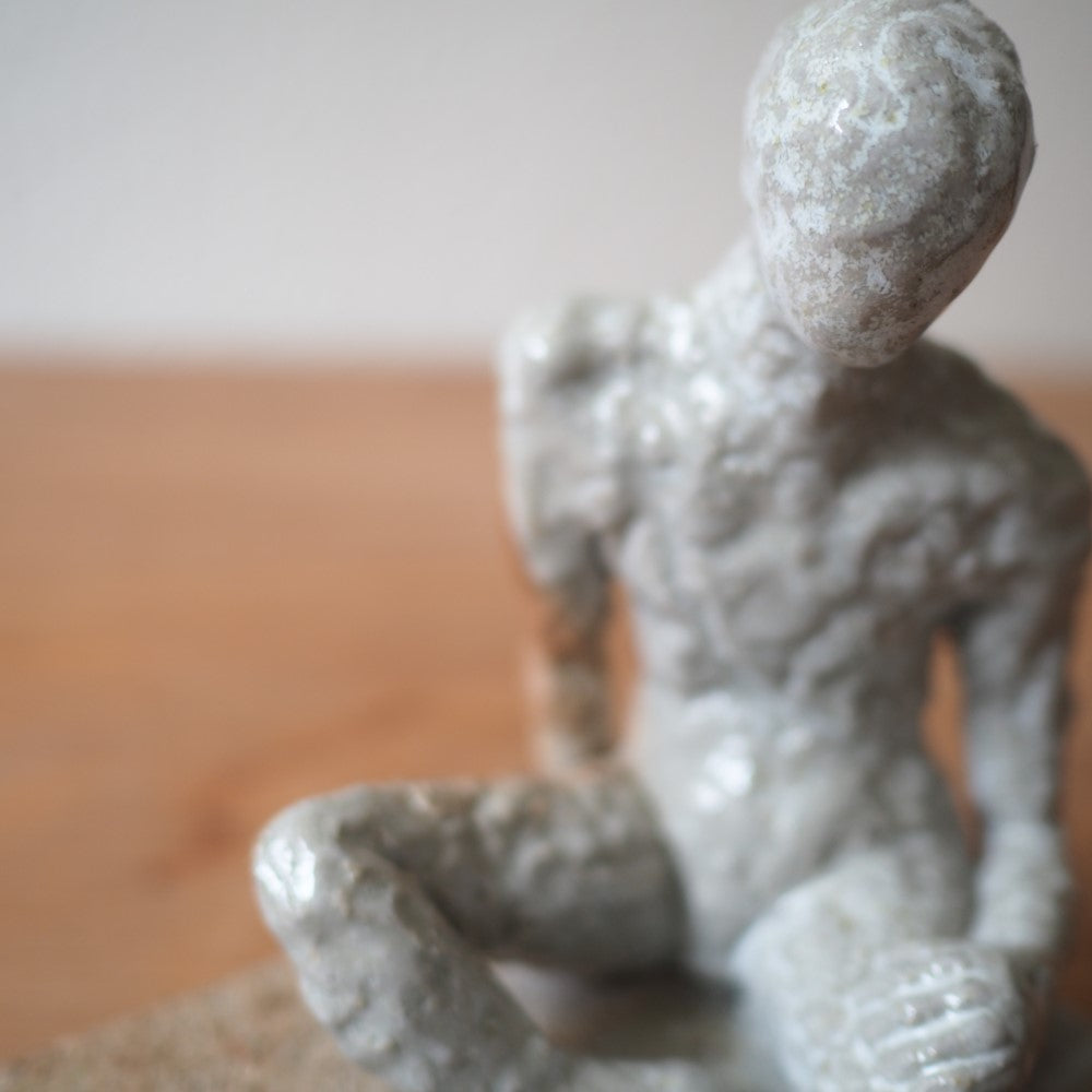 Sitting figure on a slab