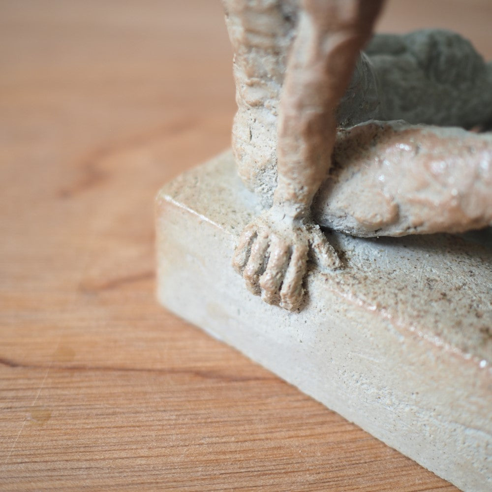 Sitting figure on a slab